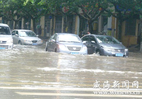 8月28日,文登市区降下暴雨,10时30分,在峰山路与龙山路交会处路面积水深约30厘米,已经没过汽车前保险杠。 8月28日,文登市区降下暴雨,10时30分,在峰山路与龙山路交会处路面积水深约30厘米,已经没过汽车前保险杠。