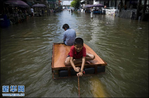 10月28日,在泰国首都曼谷,儿童借助木架经过洪灾淹没的街道。(新华社记者吕小炜摄) 10月28日,在泰国首都曼谷,儿童借助木架经过洪灾淹没的街道。(新华社记者吕小炜摄)