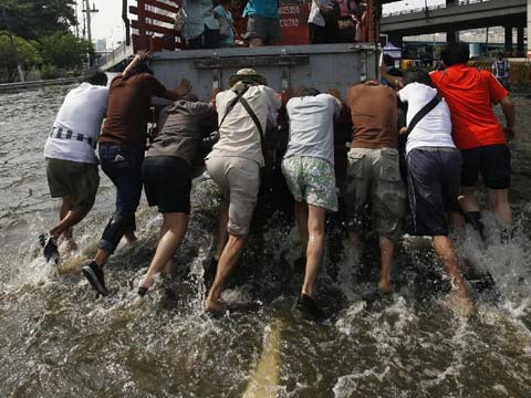 2011年11月5日泰国洪灾持续11月5日,人们推动一辆卡车在泰国曼谷被洪水淹没的街道上艰难前行。 2011年11月5日泰国洪灾持续11月5日,人们推动一辆卡车在泰国曼谷被洪水淹没的街道上艰难前行。